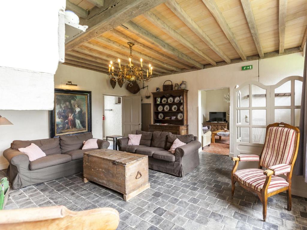 a living room with couches and a chandelier at Beernem Farmhouse with Pool in Beernem