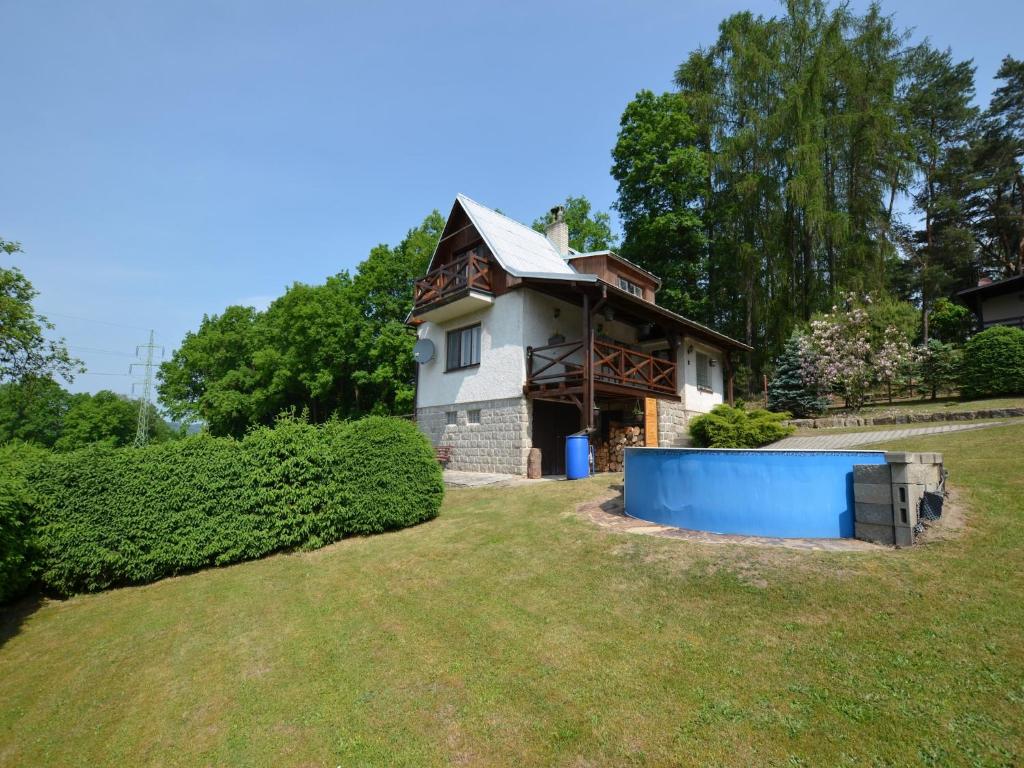 a small house with a blue garage in the yard at Mountain Retreat with Pool in Hnanice