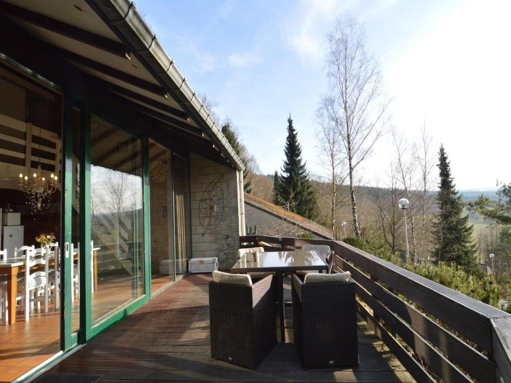 a balcony of a house with a table and chairs at Bungalow with View near Coo in Stavelot
