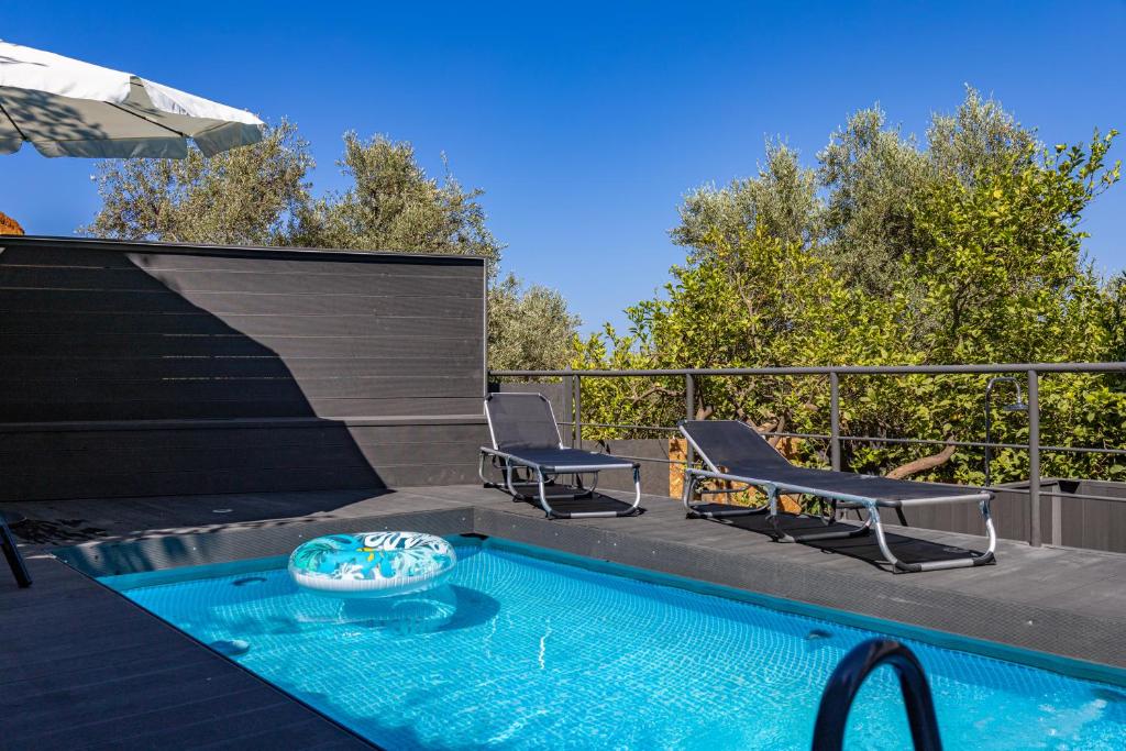 a swimming pool with two chairs and an umbrella at Blissful Residence with Private Pool by 8essentially in Daratso