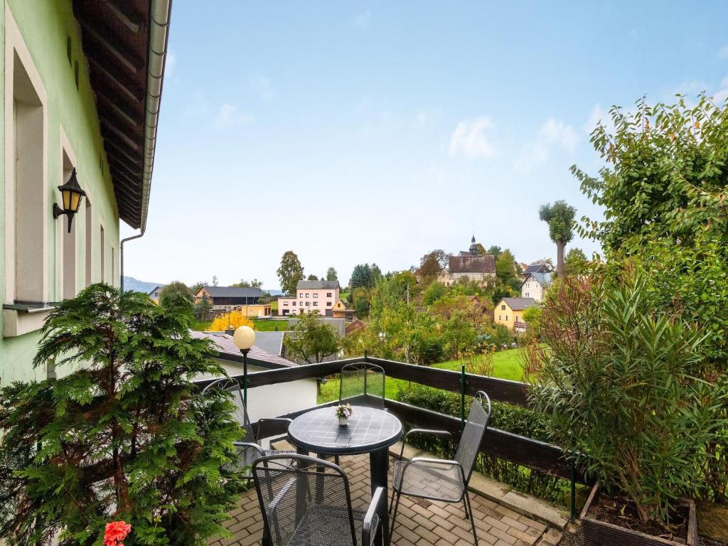 a patio with a table and chairs on a balcony at idyllische Ferienwohnung in Lichtenhain in Lichtenhain
