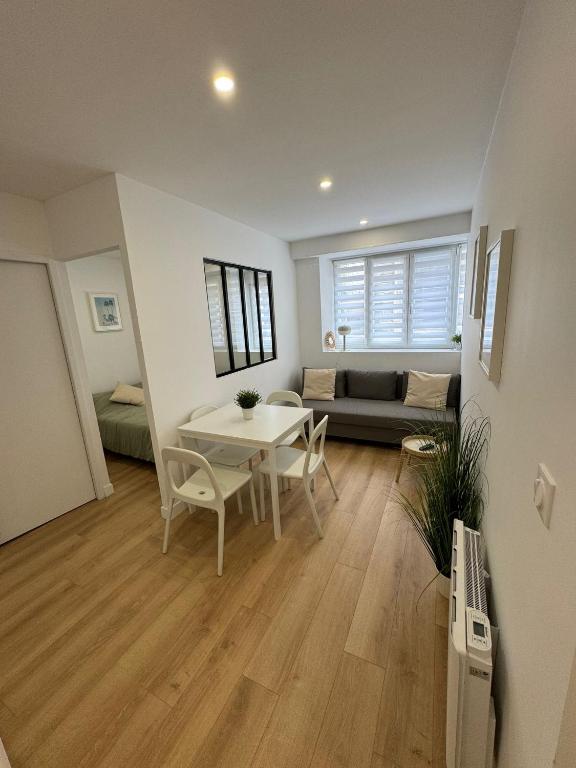 a living room with a table and a couch at Mallorca, plein centre avec parking in Reims