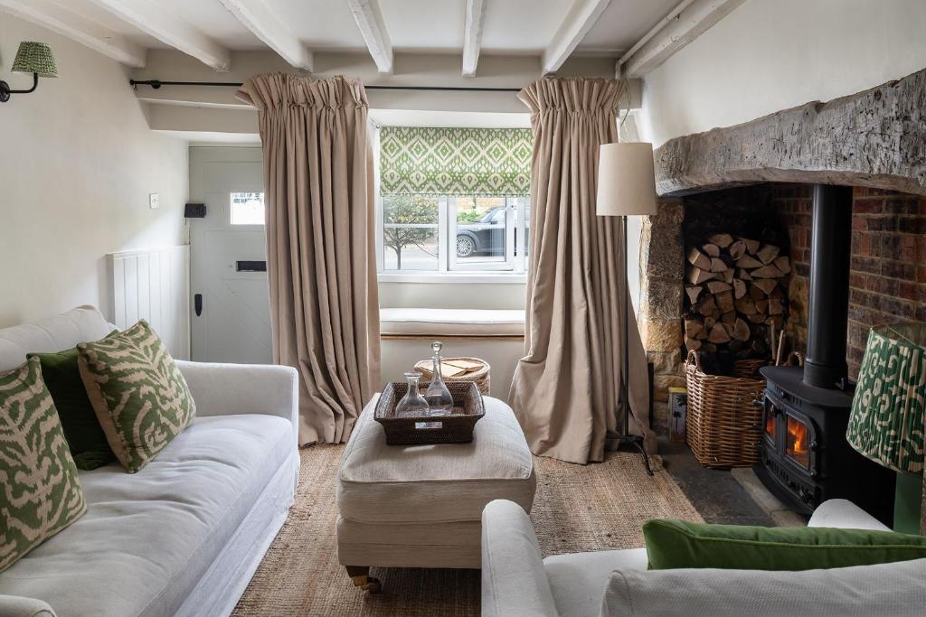 a living room with a couch and a fireplace at Little House in Deddington