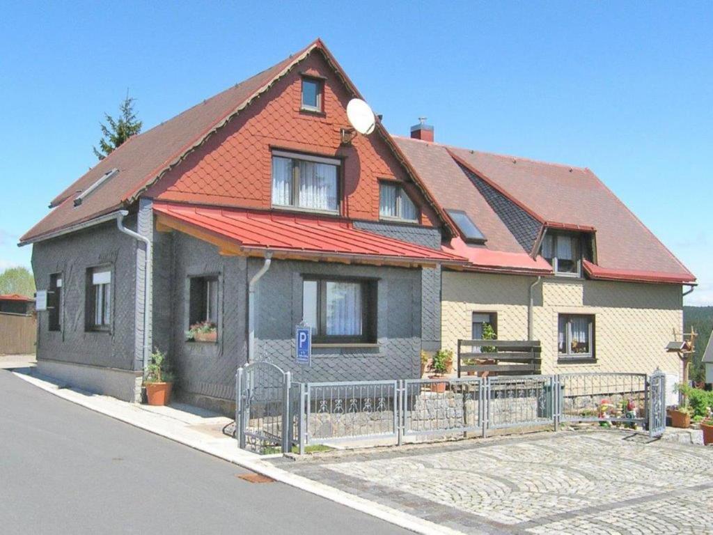 a house with an orange roof and a fence at Serene Stay with Garden in Frauenwald