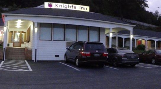 Deux voitures garées dans un parking en face d'une auberge de nuthatches dans l'établissement Knights Inn Galax, à Galax