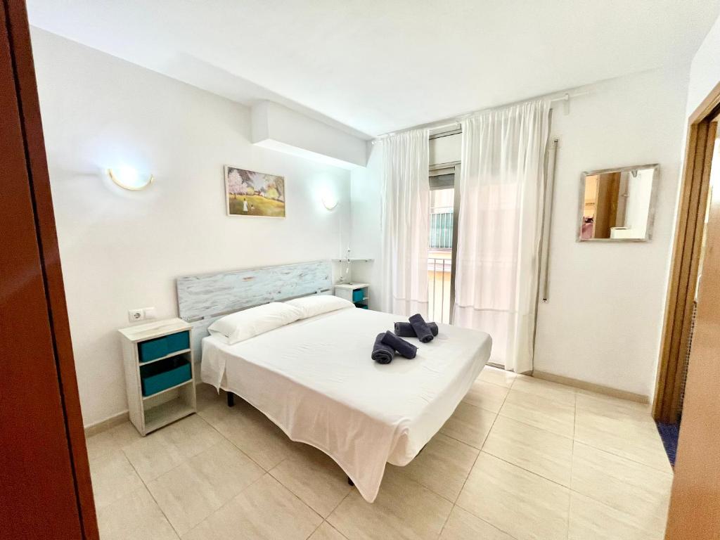 une chambre avec un lit blanc et une fenêtre dans l'établissement Fantástico apartamento en Sant Antoni, a solo 1 minuto de la playa, à Calonge