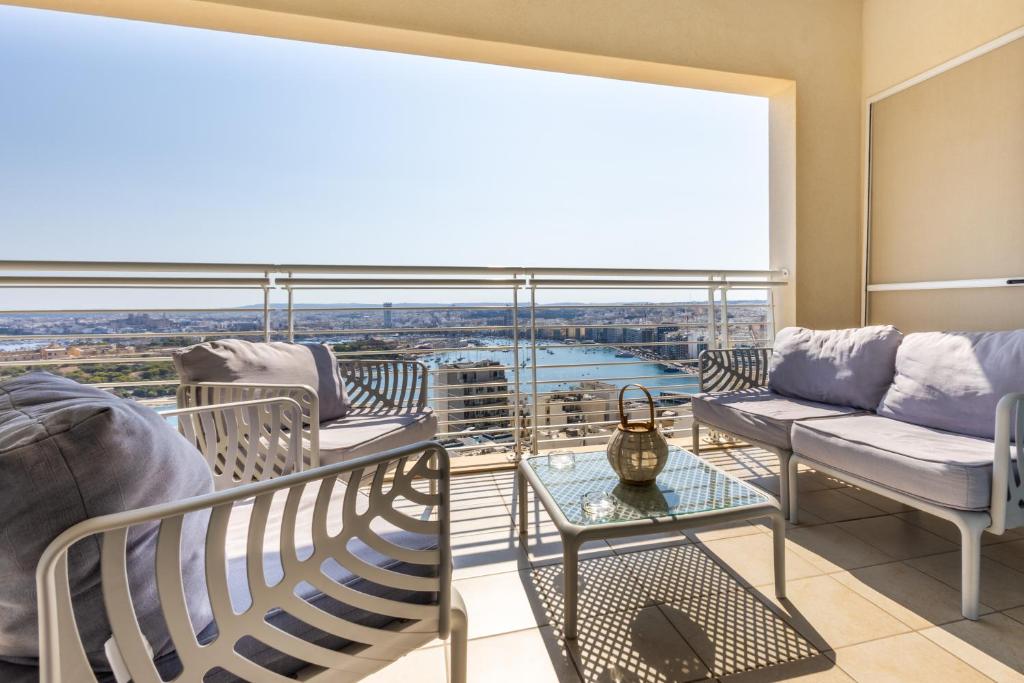 a balcony with couches and a view of the city at 16th Floor with Pool & 180 Sea Views by QuickTrips in Sliema