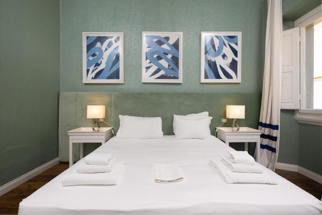 1 dormitorio con 1 cama grande y 3 cuadros en la pared en Fossi Street Central Apartment, en Florencia