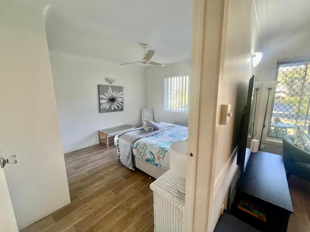 Un dormitorio pequeño con una cama y una ventana. en Beachfront at Silver Sands Hervey Bay, en Hervey Bay