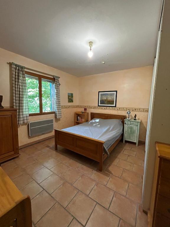 a bedroom with a bed and a window at Chez Mamie in Cazes-Mondenard