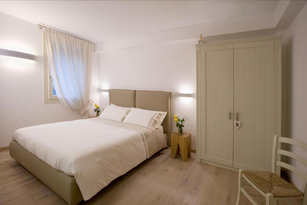 ヴァルドッビアーデネにあるCasa Bortolinのベッドルーム(白い大型ベッド1台、キャビネット付)