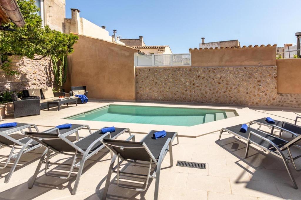 a pool with chairs and a table and a swimming pool at Horta 55 in Pollença