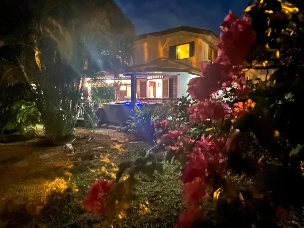 Rémire-CampにあるVilla boisée, jacuzzi et jardin, route des plagesの花の前の家