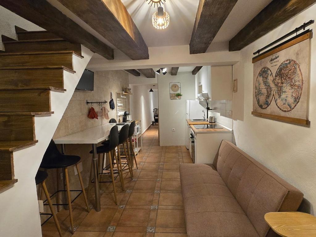 a living room and kitchen with a couch and a bar at La Cantarera del Duero in Tordesillas