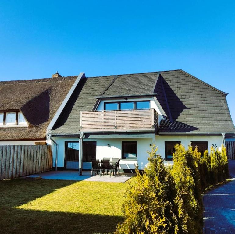 a house with a pitched roof with a patio at Ferienwohnung Felix in Ribnitz-Damgarten