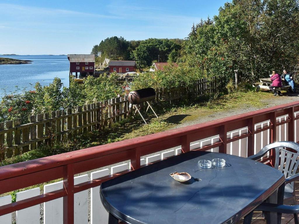 a table on a balcony with a view of the water at 6 person holiday home in Bud in Bud