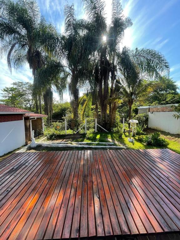 a wooden deck with palm trees in the background at Rancho Monte Verde in Elói Mendes