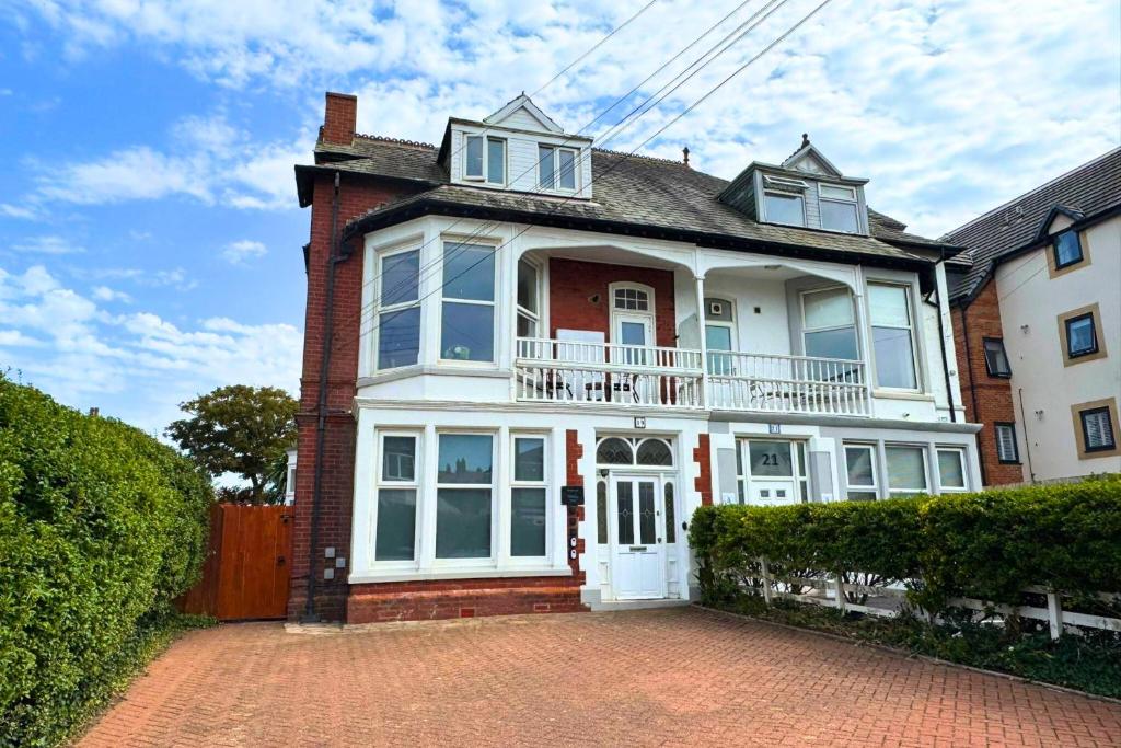 ein großes weißes Haus mit einer Ziegelsteinfahrt in der Unterkunft Fairhaven View Apartments - Lytham St Annes in Lytham St Annes