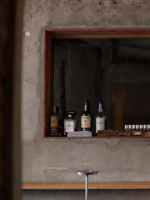 a shelf with bottles of alcohol sitting on it at nook Inn in Seoul