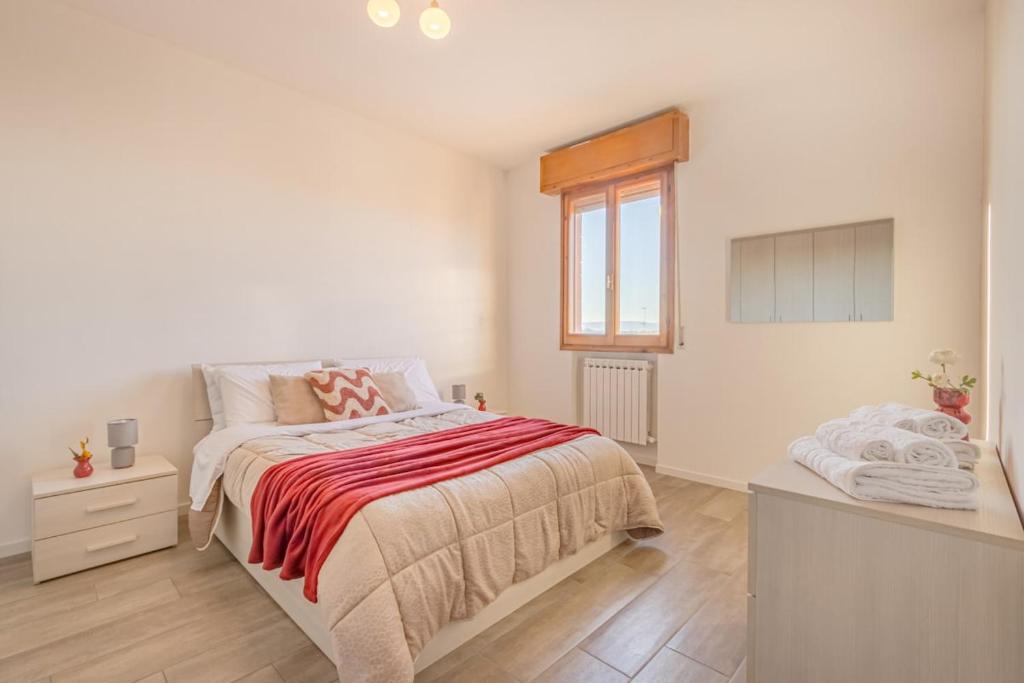 a white bedroom with a bed and a window at The Purple House between Modena and the Ferrari Museum in Modena
