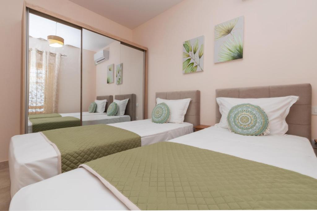 a hotel room with two beds and a mirror at Aurum Luxury Villa Voz by elite" in Laganas