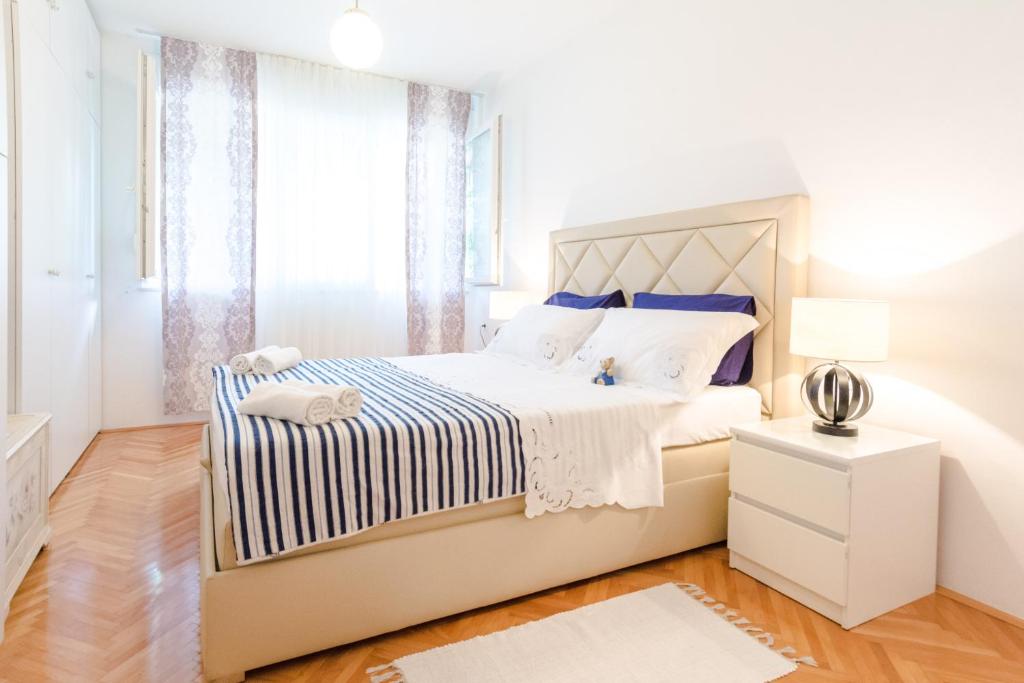 biała sypialnia z dużym łóżkiem i oknem w obiekcie Apartment Mandalina w Splicie