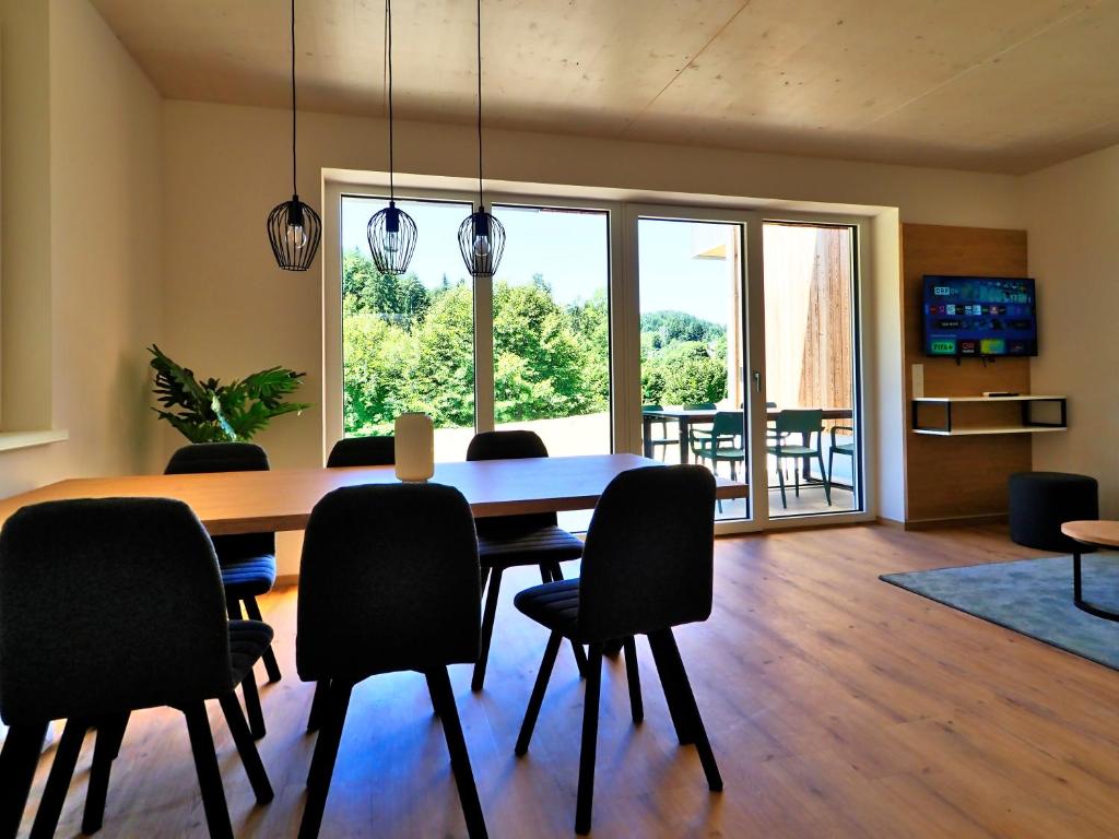a dining room with a wooden table and chairs at OpenSky Wörthersee Lodge in Pörtschach am Wörthersee