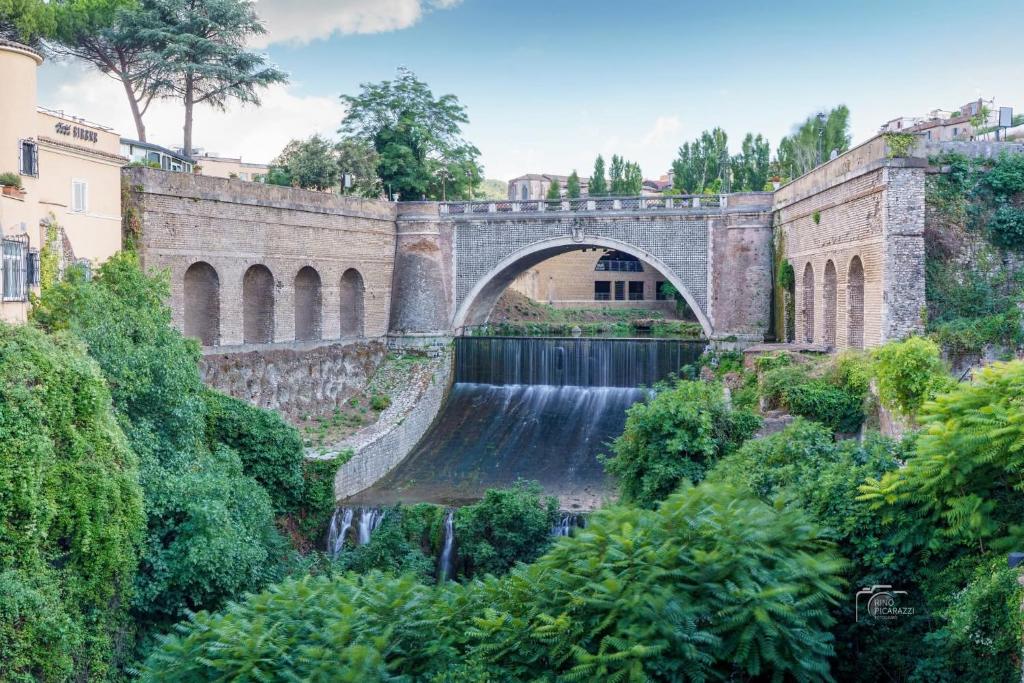 a stone bridge with a waterfall in front at ARRIVA LUI!!!Bello bello,ci pensa lui, stai tranquillo in Tivoli