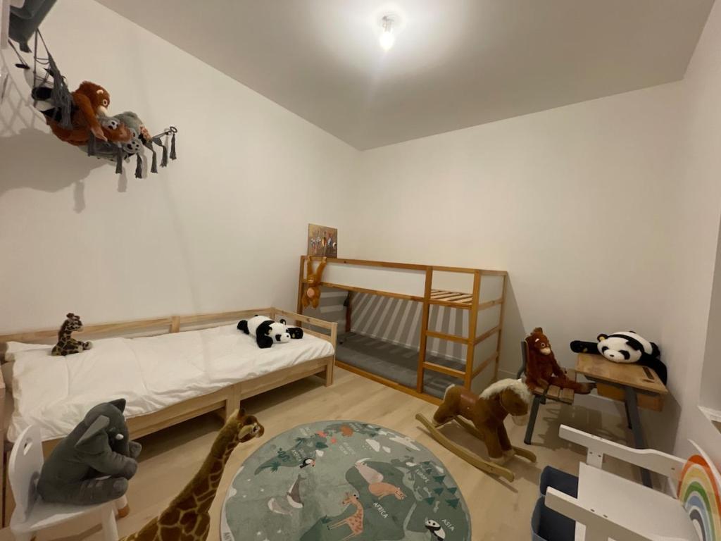 a childs room with a bed and many stuffed animals at Petite maison à coté de Beauval & Chateaux in Meusnes