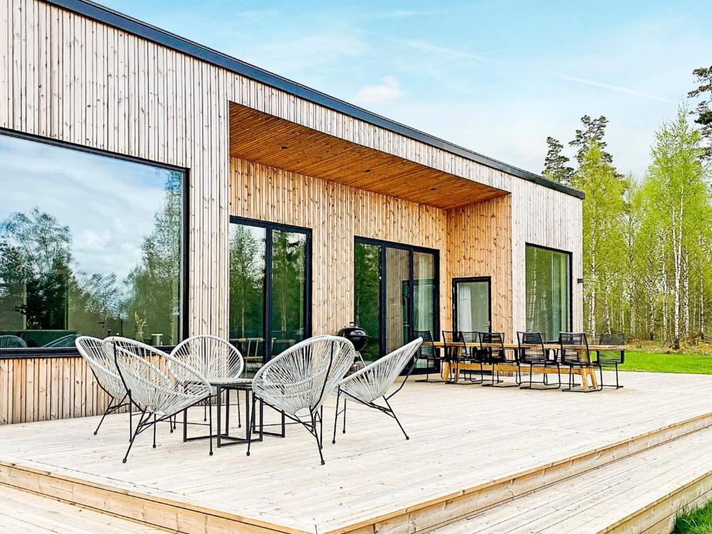 a patio with chairs and a table on a wooden deck at 4 star holiday home in Håcksvik in Håcksvik