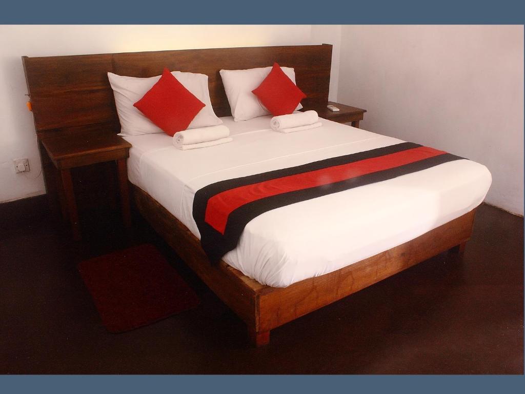 een slaapkamer met een groot bed met rode kussens bij 256 Townhouse Rest in Kandy