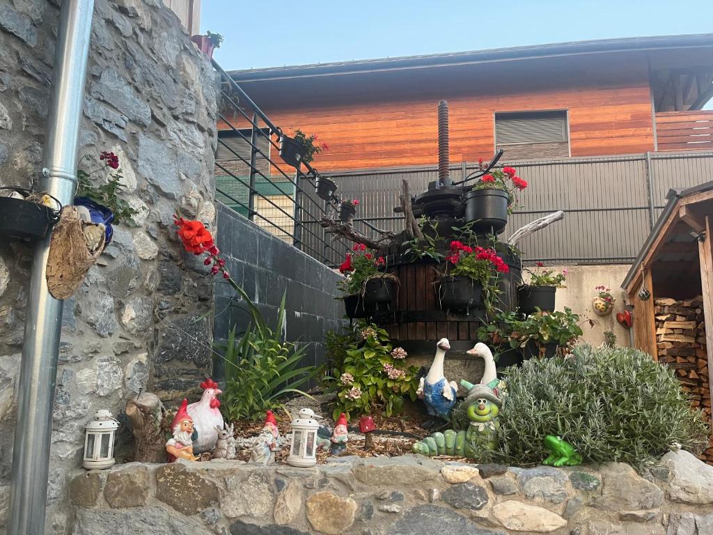 a garden with figurines and flowers on a wall at Sub zéro in Saint-Jean-de-Tholome