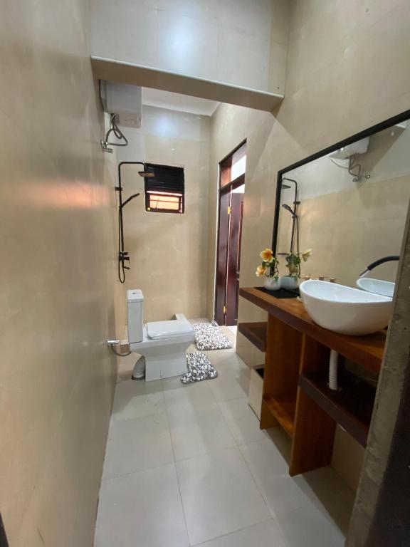 a bathroom with a sink and a toilet and a mirror at Kira Garden Villas in Jinja