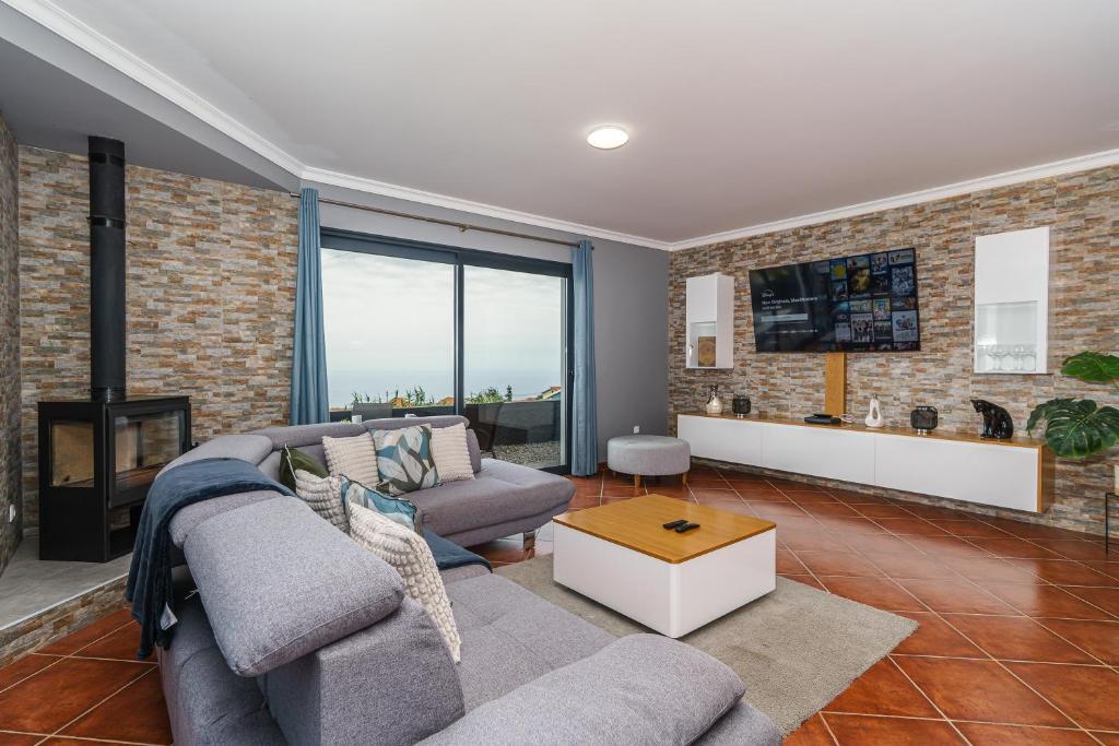 salon z kanapą i kominkiem w obiekcie Villa Werner by Madeira Dream Stays w mieście Ponta do Pargo