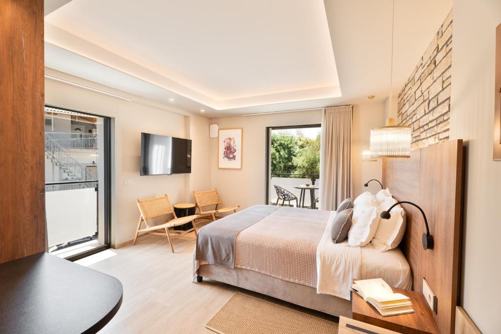 a hotel room with a bed and a dining room at Dioni Suites Syvota in Sivota