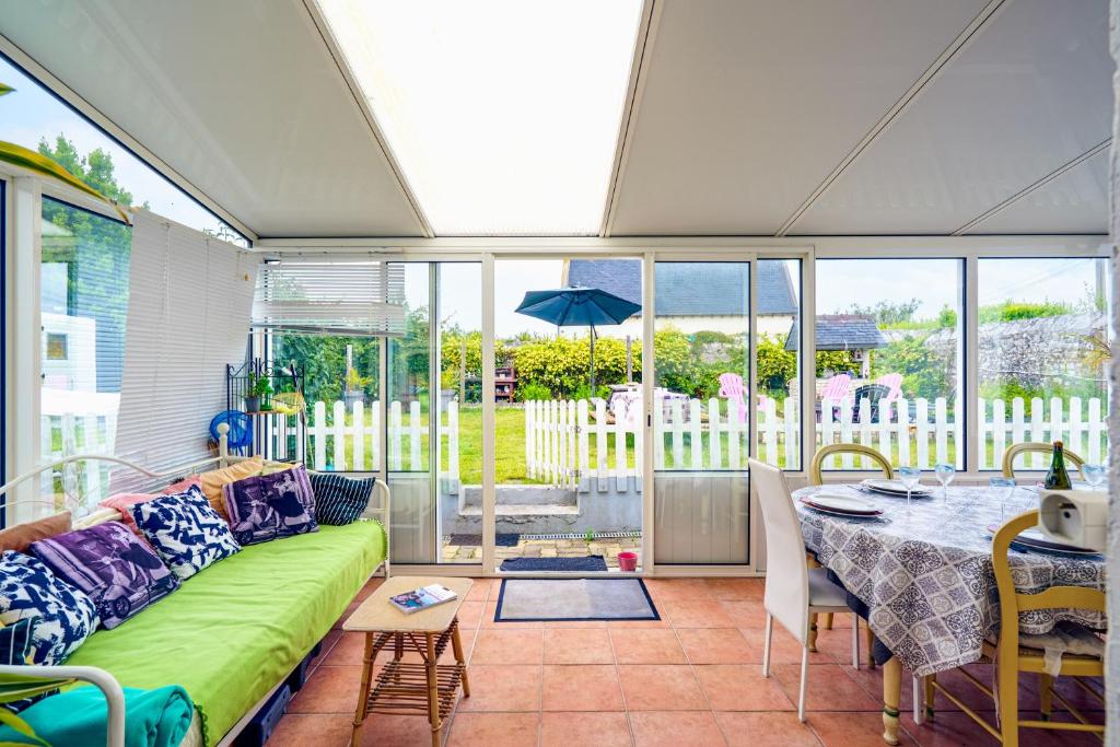 ein Wohnzimmer mit einer grünen Couch und einem Tisch in der Unterkunft Ty Provans e Breizh - Maison pour 12p in Primelin