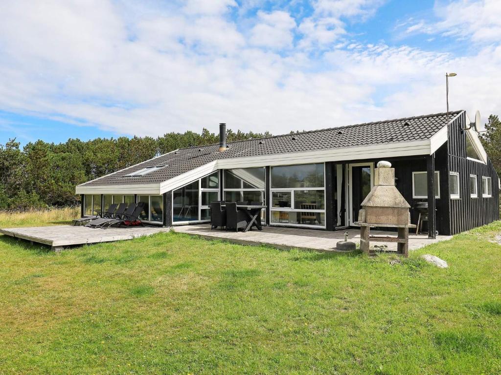 a black house with a lot of windows at 8 person holiday home in Løkken in Løkken