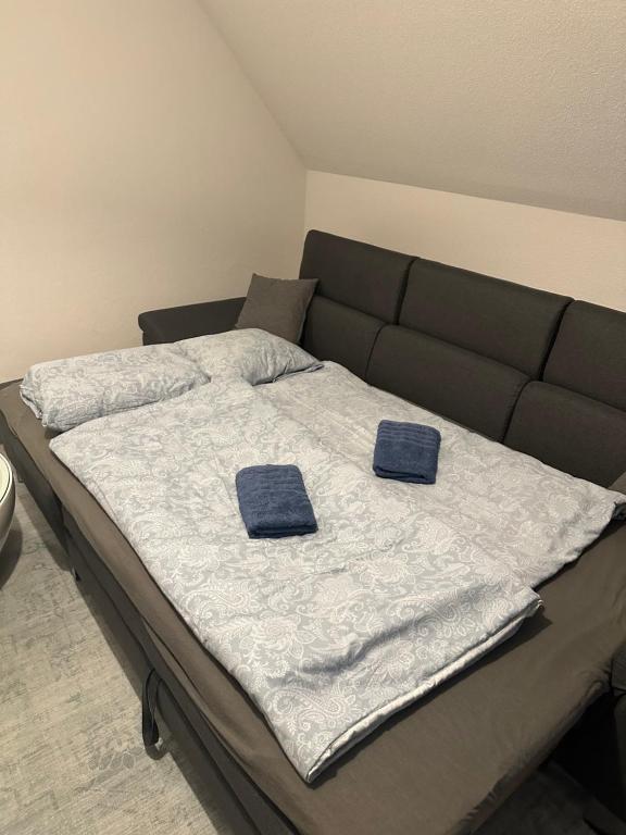 a bed with two blue towels on top of it at Ferienwohnung Altstadtblick in Wolframs-Eschenbach