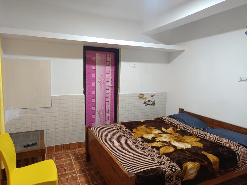 a bedroom with a bed and a yellow chair at Osprey individual Cottage in Ooty