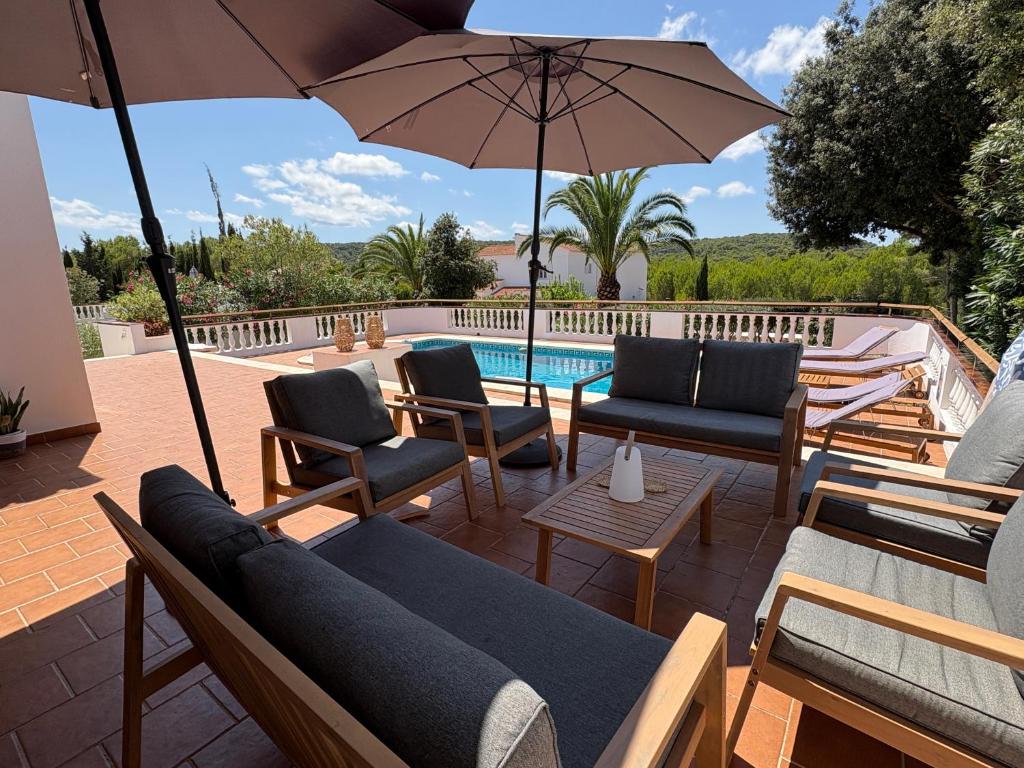 patio con sedie, ombrellone e piscina di La FINCAD4 entre plages et Forêt a Son Parc