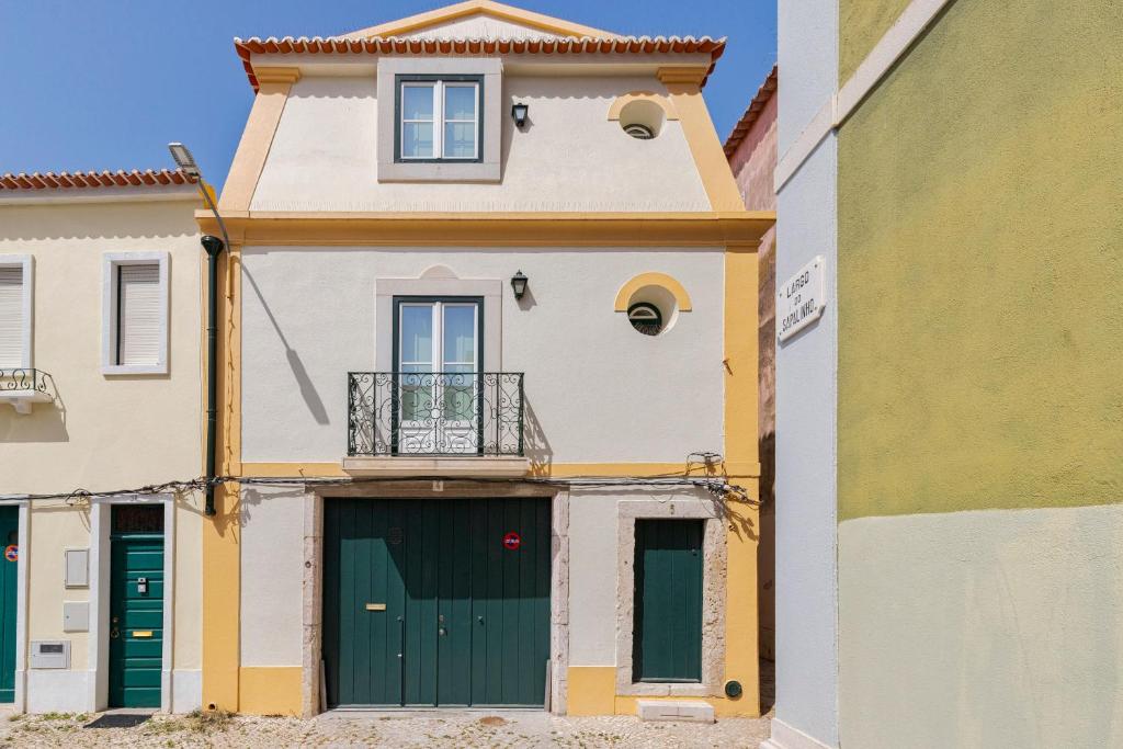 a building with a green door and a balcony at Sapalinho Retreat - By Y Concept in Setúbal