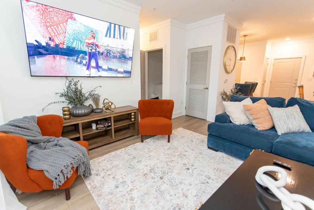 ein Wohnzimmer mit einem blauen Sofa und orangefarbenen Stühlen in der Unterkunft Beautiful Apartment in Concord with swimming pool and Gymn in Charlotte