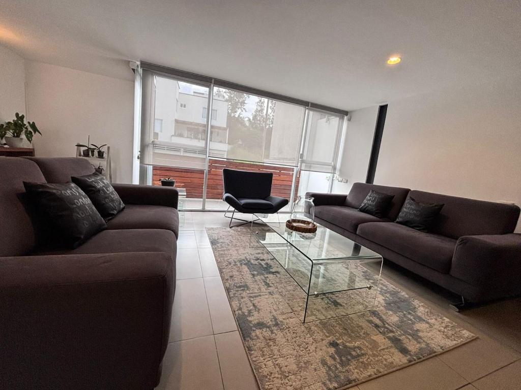 a living room with two couches and a glass table at Xalapa Monte Novo Contemporary House in Xalapa