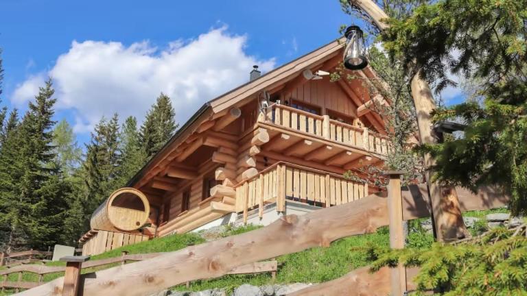 a log cabin with a large deck on a hill at Bründl-Chalets Hochrindl in Sirnitz-Sonnseite