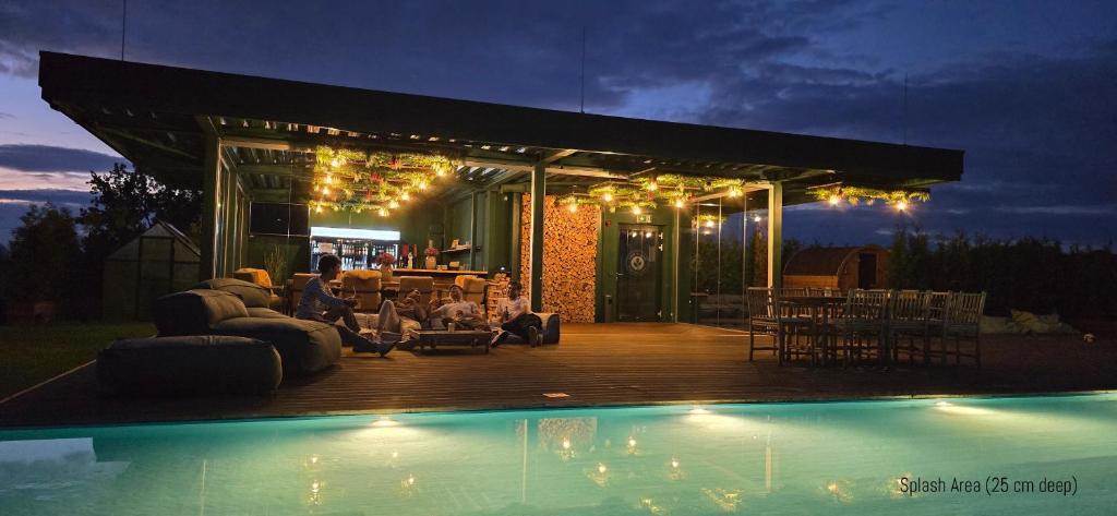 a house with a deck next to a pool at night at Hannover - PHIL & MAX Hotels und Apartments Messe in Hannover