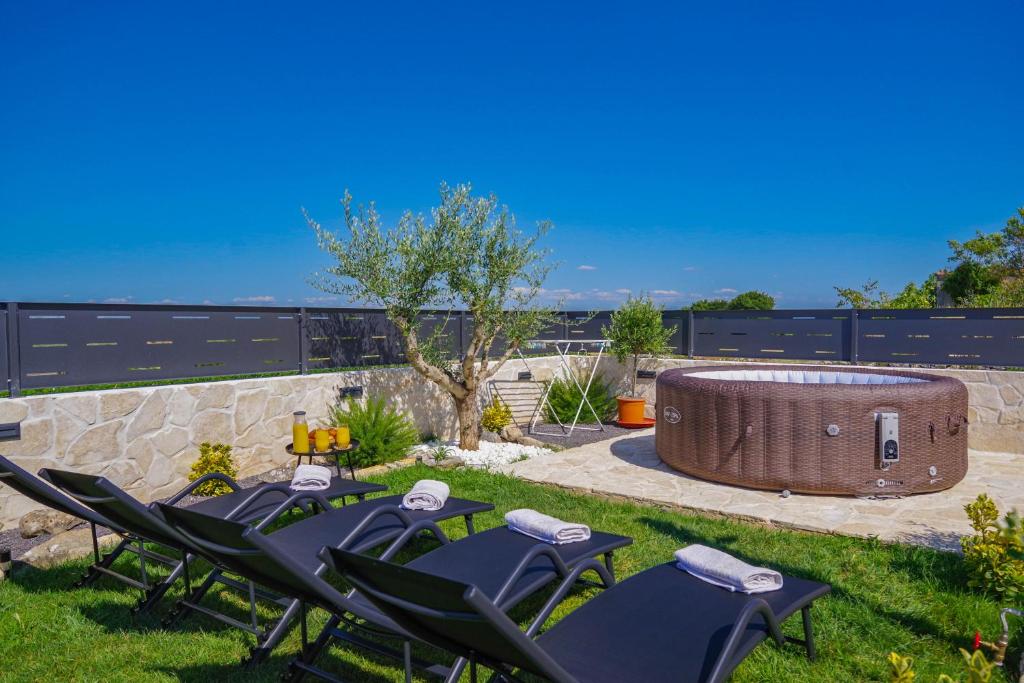 a group of chairs in a yard with a hot tub at Villa Romana in Bibinje
