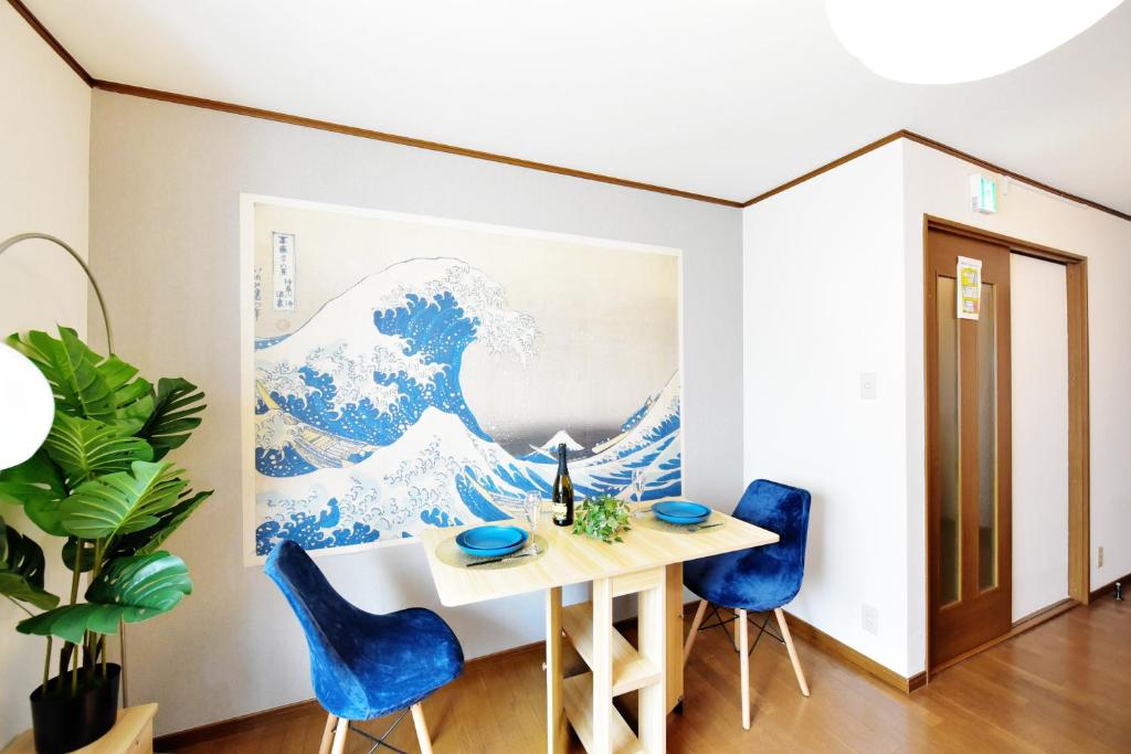Un comedor con un cuadro de la gran ola en Tsumugu art base, en Osaka