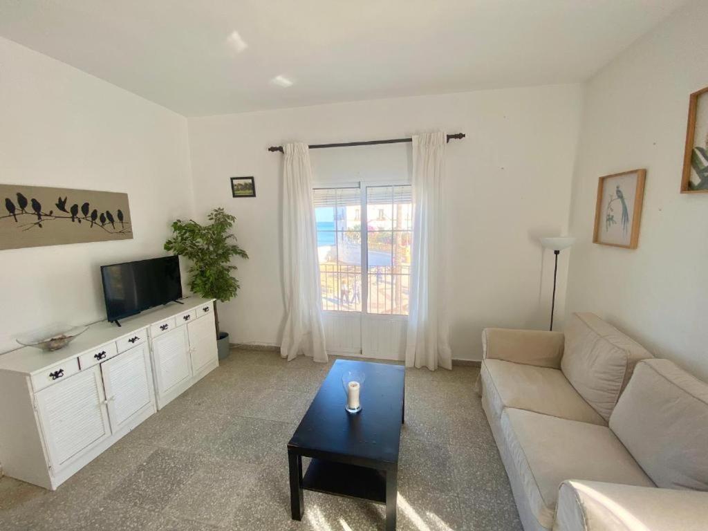 a living room with a couch and a tv at Gran alojamiento a 1 metro de la playa con magnificas vistas in Chipiona