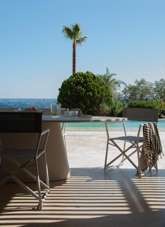 a table and two chairs and a palm tree at Alykes Villa - Seaview escape in Plakias