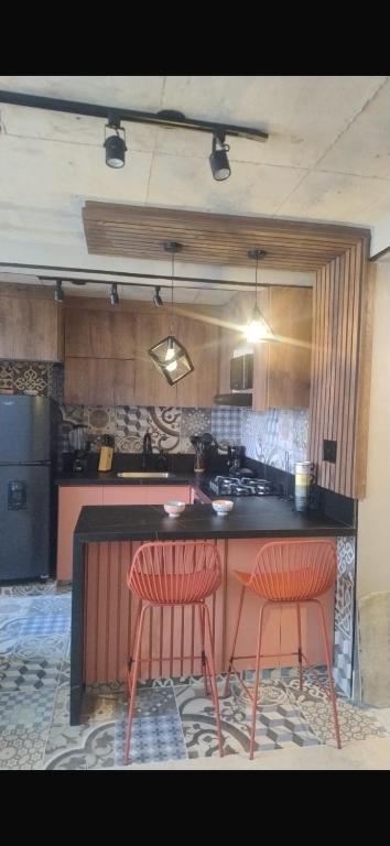 a kitchen with two red chairs at a counter at Barranquilla Dreams in Puerto Colombia